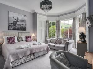 a bedroom with a bed and a couch and a chair at Atholl Arms in Blair Atholl