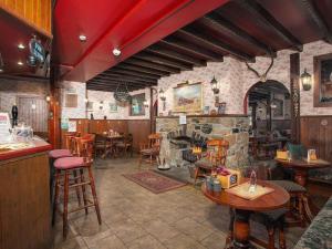 a restaurant with a stone fireplace and tables and chairs at Atholl Arms in Blair Atholl