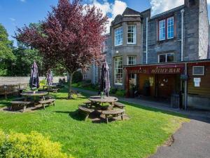 a group of picnic tables in front of a building at Atholl Arms in Blair Atholl