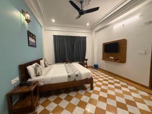 a bedroom with a bed and a flat screen tv at Vista villa in Pushkar