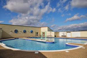 a large swimming pool in front of a building at 8 Berth Caravan - Blue Dolphin - Filey in Gristhorpe