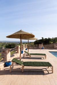 two lounge chairs and an umbrella next to a pool at Villa Luxury Spacious Moroccan ,Private Pool in Essaouira