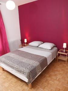 a bedroom with a bed with a purple wall at La Maison d'hôtes Antaram in Nyons