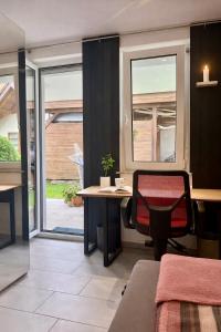 an office with a desk and a chair and windows at Zentrales Apartment in Friedrichshafen mit Terrasse für bis zu 5 Personen in Friedrichshafen +5 photos