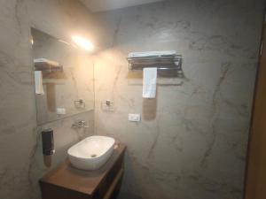 a bathroom with a white sink and a mirror at Hotel Vardaan Inn in Lucknow