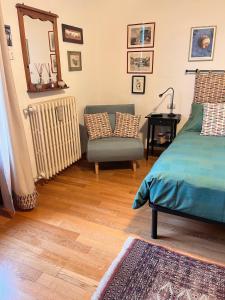 ein Schlafzimmer mit einem Bett, einem Stuhl und einem Spiegel in der Unterkunft OnlyOne in Scandicci