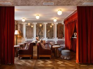 a barber shop with red curtains and chairs and tables at The Hotel Lili in Los Angeles