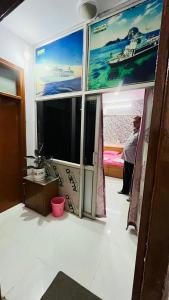 a room with a large window with a large tv at Marble Man Homestay in Agra +8 photos