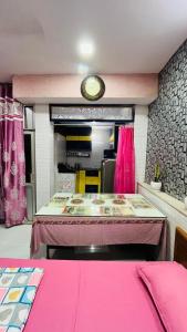 a room with a table and a clock on the wall at Marble Man Homestay in Agra