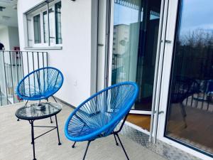 two blue chairs and a table on a balcony at M2Suites by BestChoice - Messe - Parking - Self-Check-in in Graz