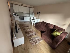 a living room with a brown couch and a kitchen at Vabaduse tn 72 in Narva-Jõesuu