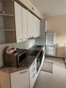 a kitchen with white cabinets and a microwave on a counter at Vabaduse tn 72 in Narva-Jõesuu