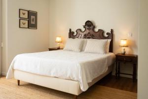 ein Schlafzimmer mit einem großen weißen Bett und zwei Nachttischen in der Unterkunft Casa d`Acucanha in Penafiel