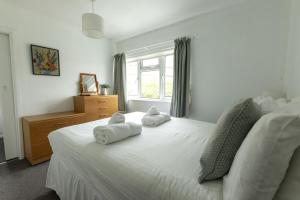 a bedroom with two towels on a bed with a window at Waterwitch Cottage in Newquay