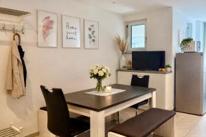 a dining room with a table and a refrigerator at Zentrales Apartment in Friedrichshafen mit Terrasse für bis zu 5 Personen in Friedrichshafen