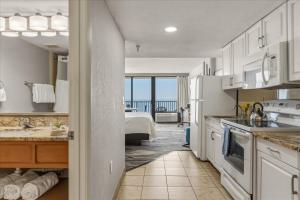 a kitchen with white cabinets and a view of the ocean at Nautilus Inn - Daytona Beach in Daytona Beach