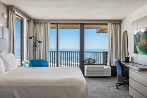 a hotel room with a bed and a view of the ocean at Nautilus Inn - Daytona Beach in Daytona Beach +95 photos
