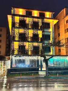 ein Gebäude an einer Straße mit einem Baum davor in der Unterkunft ALEE BEYZAR Hotel in Ankara