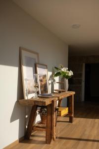 ein Tisch mit einem Bild und einer Blumenvase darauf in der Unterkunft Casa d`Acucanha in Penafiel