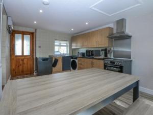 a large kitchen with a wooden table in it at Gate House in Llangefni