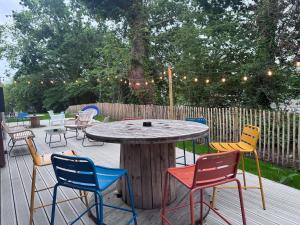 a wooden table and chairs on a deck with a table at Greet Hotel Brest Aéroport in Guipavas