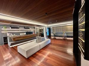 a living room with a white couch and wooden floors at Restinga 305- Flat vista mar no Bessa - ASKA in João Pessoa