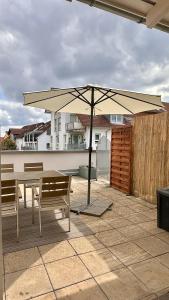 a patio with two benches and an umbrella at AMAO-Sienna - Walk to Europa-Park - Terrace - 6 Guests in Rust