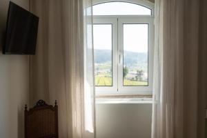 ein Fenster mit einem weißen Vorhang in einem Zimmer in der Unterkunft Casa d`Acucanha in Penafiel