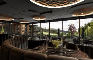 a restaurant with tables and chairs and a large window at Viktoria Alpine Hideaway in Avelengo