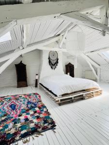 a bedroom with a bed in an attic with a rug at Maison Quercus in Vaylats