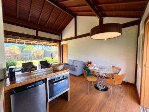 a kitchen and living room with a table and chairs at Chalet Monte Boa Vista - Aconchego na Serra com Hidromassagem Exclusiva in Teresópolis