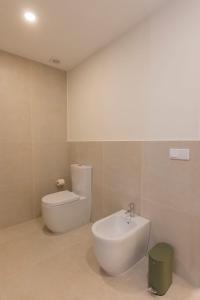 a bathroom with a white toilet and a bidet at Coração dos Arcos in Arcos de Valdevez