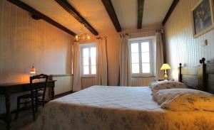 a bedroom with a bed and a desk and two windows at Chambre n4 Maison dHôtes de Charme in Maizières +5 photos