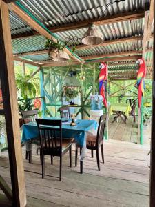 a blue table and chairs in a covered patio at Maiku Amazonas in Puerto Nariño