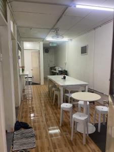 a room with tables and stools in a room at Sejiwo Apartment 6-8pax in Pengkalan Cepa