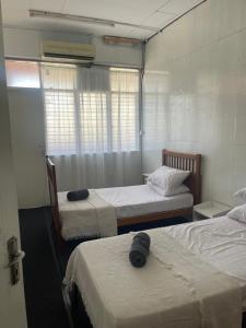 a room with two beds and a window at Sejiwo Apartment 6-8pax in Pengkalan Cepa