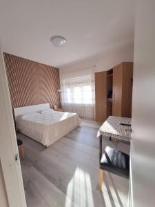 a bedroom with a bed and a table and a window at Giada Rooms appartments in Peschiera del Garda +3 photos