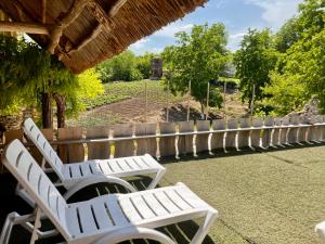 a row of white chairs sitting on a patio at Hanul lui Hanganu in Lalova