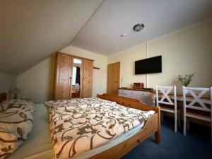 a bedroom with a large bed and a television at Ferienhaus Villa Deichfürst in Dorum-Neufeld