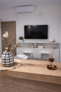a living room with a table with a vase with flowers at AGNI Suite Centro in Concepción del Uruguay