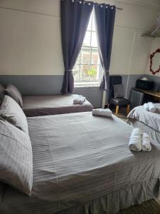 a bedroom with two beds and a window at Spalite Hotel in Gloucester