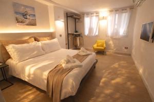 a bedroom with a large white bed with a yellow chair at Noor Palace - PI Collection Hotel in Palermo