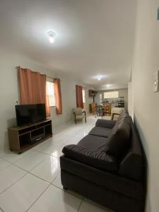 a living room with a black leather couch and a tv at Ed The Rock in Belém