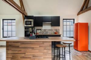 a kitchen with an orange refrigerator and a counter at Large bright apartment in Lessines +2 photos