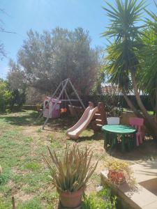 a playground with a slide and a table at Paulina's House in Politika