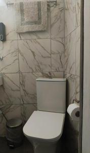 a white toilet in a bathroom with marble walls at Mia Nest in Artemida +13 photos