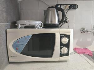 a microwave with a tea kettle on top of it at Mia Nest in Artemida