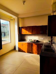 a kitchen with wooden cabinets and a window at Red Brick Home stay in Kulu