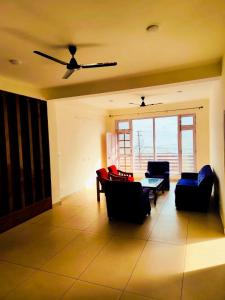 a living room with couches and a table and chairs at Red Brick Home stay in Kulu