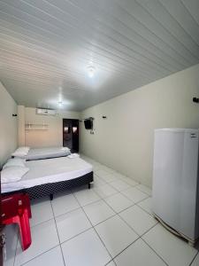 a room with a bed and a tv in it at Pousada e Chalés mar e sol in Manibu